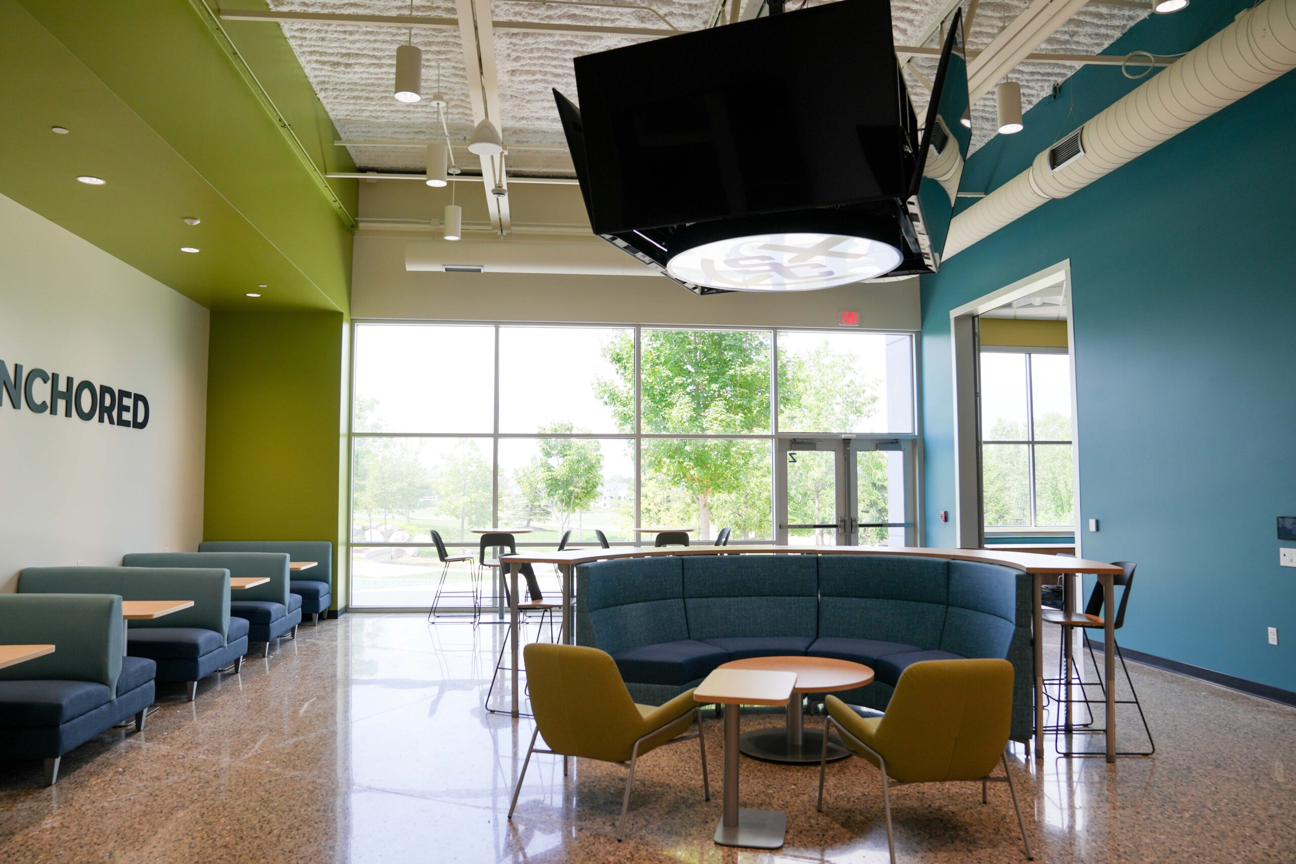 Student lounge at South Christian High School with Anchored branding, modern seating, and Buist’s electrical work.