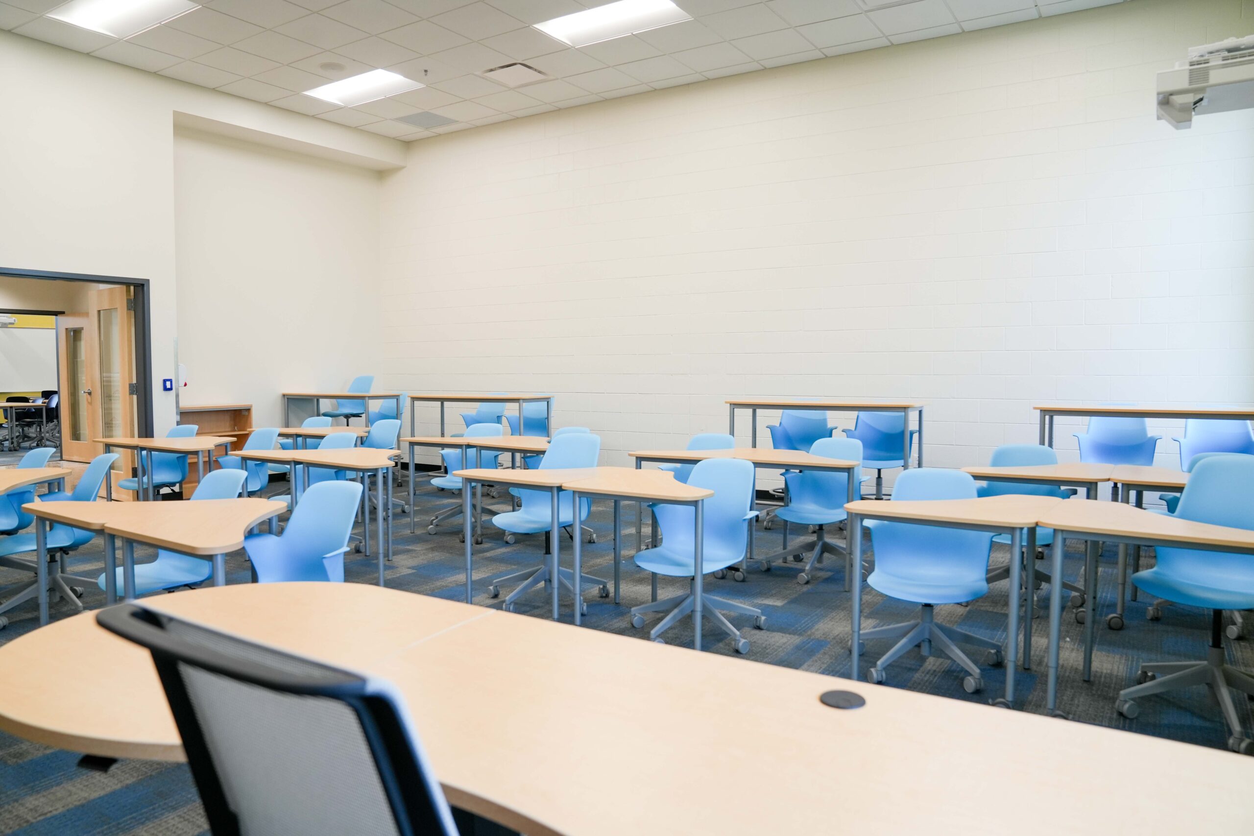 Classroom at South Christian High School with flexible blue seating and Buist’s lighting and electrical systems supporting modern learning spaces.