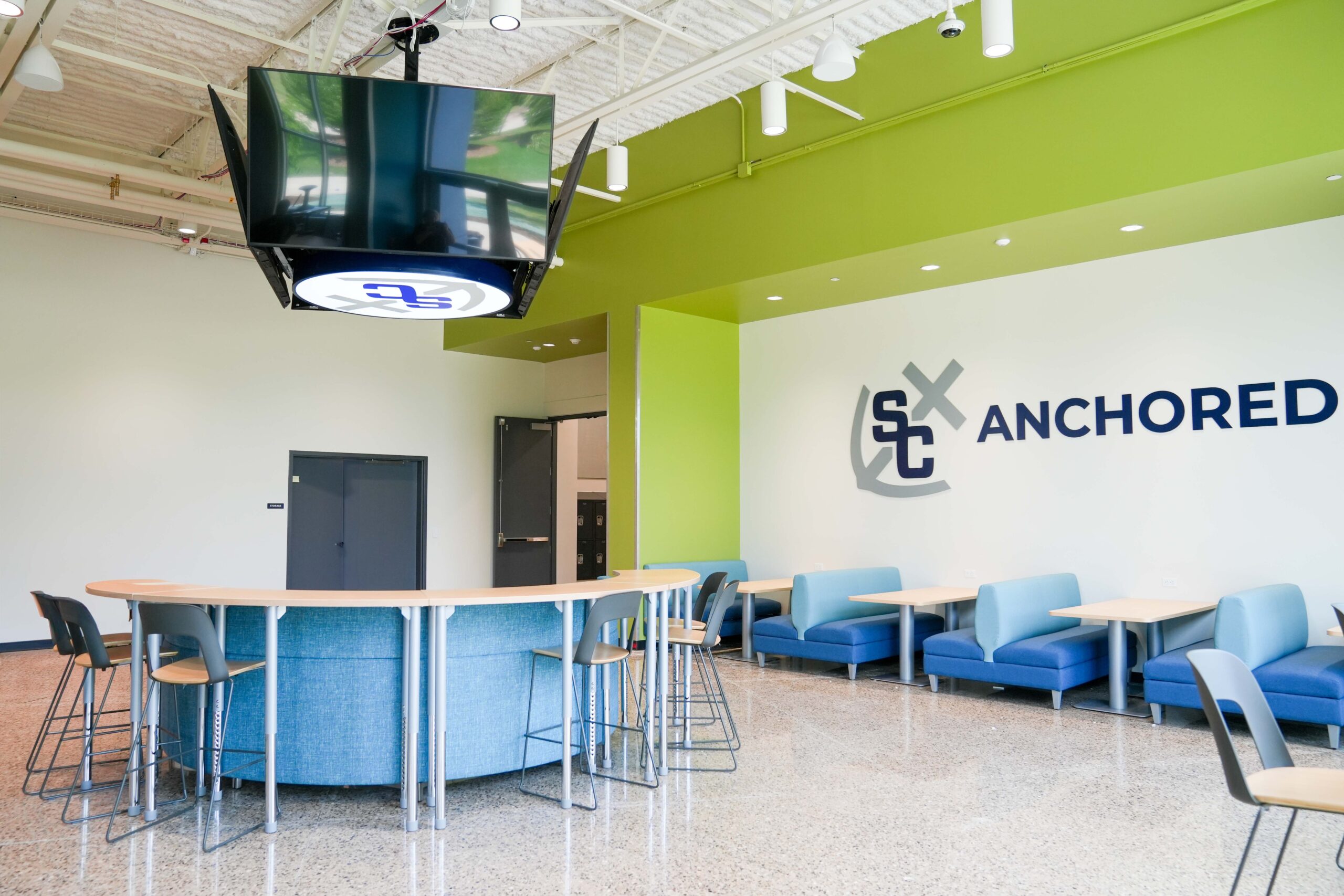 Anchored student lounge at South Christian High School with modern seating, large windows, and electrical work completed by Buist.