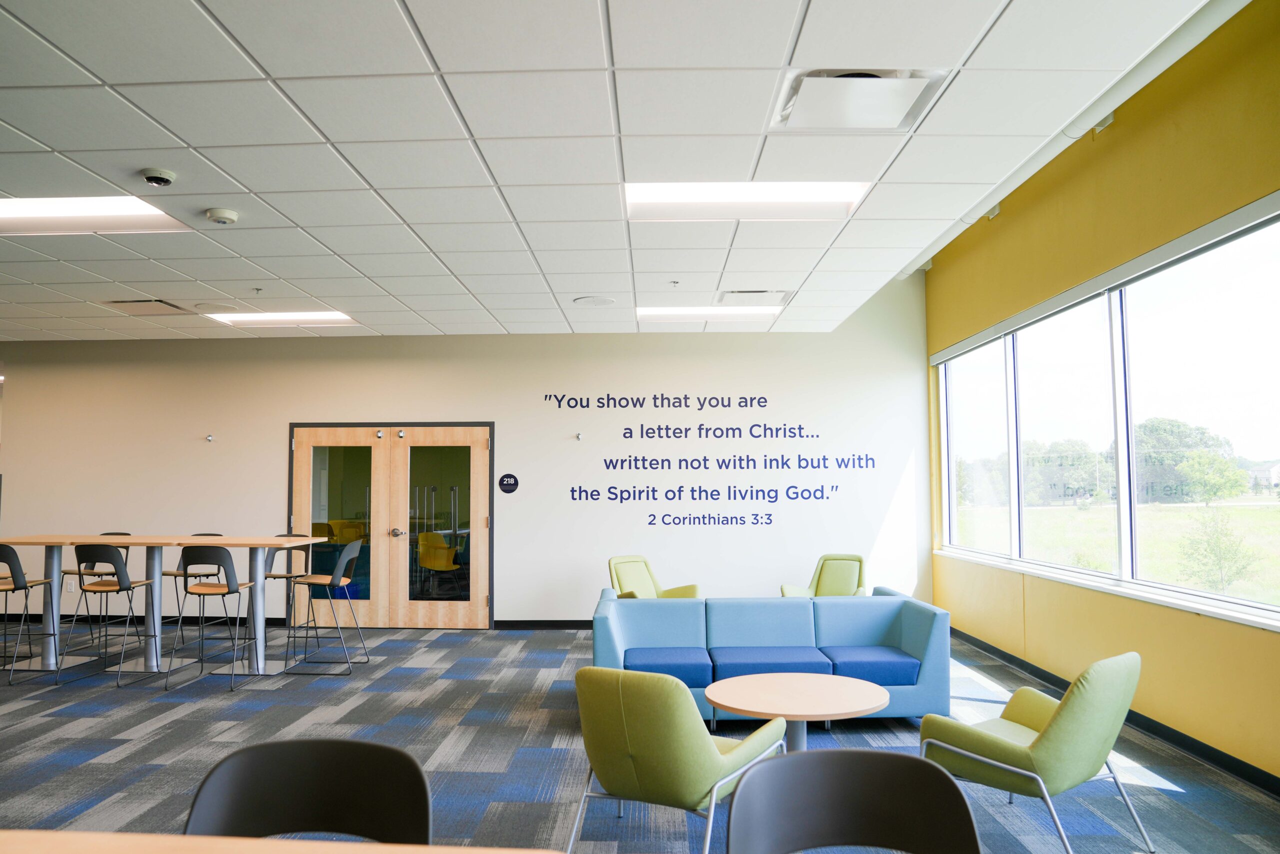 Interior wall at South Christian High School featuring 2 Corinthians 3:3 scripture, with Buist’s lighting and electrical systems enhancing the design.