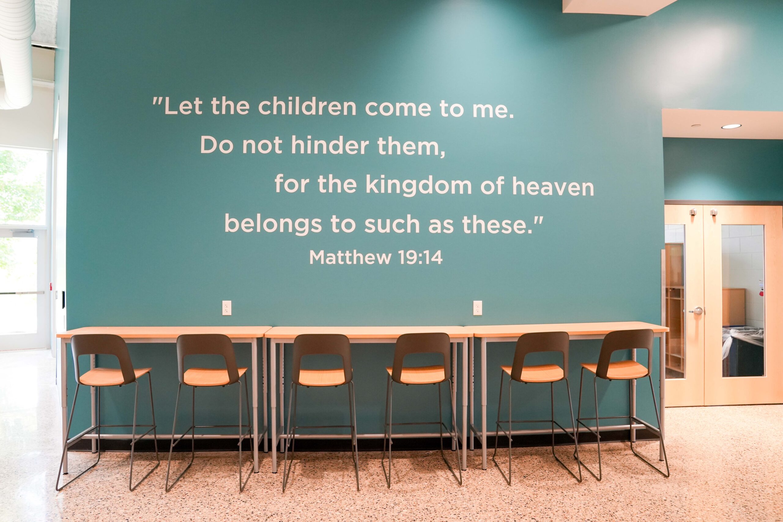 Interior scripture wall at South Christian High School featuring Matthew 19:14 with Buist’s electrical work supporting the modern design.