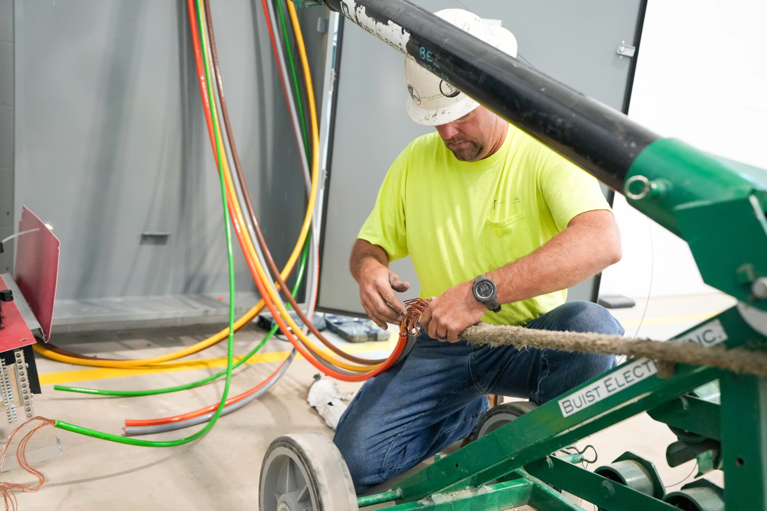 Buist electrician preparing electrical cables for installation during construction.