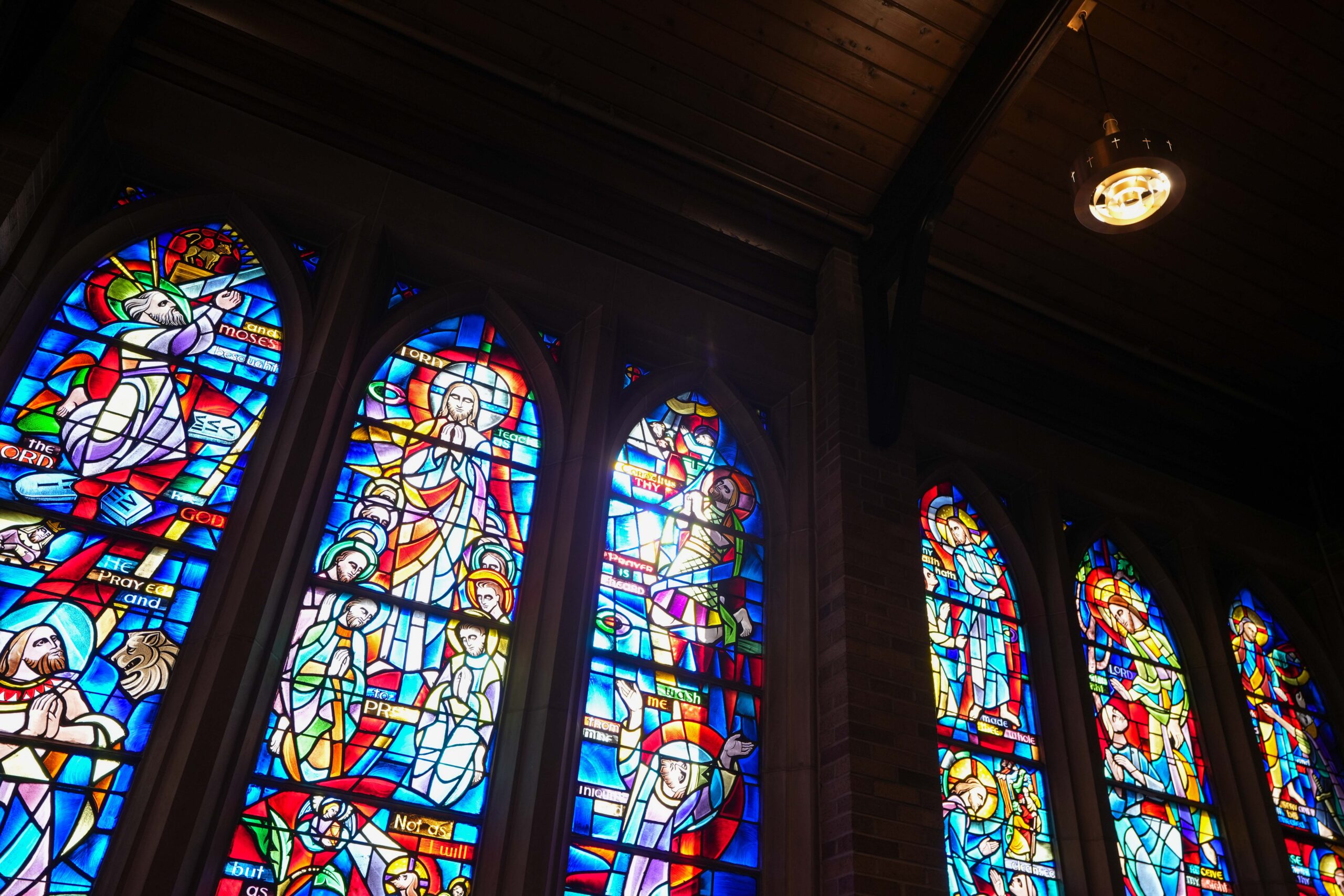 Stained-glass windows inside LaGrave Avenue Christian Reformed Church in Grand Rapids, Michigan, illuminated by new sanctuary lighting.