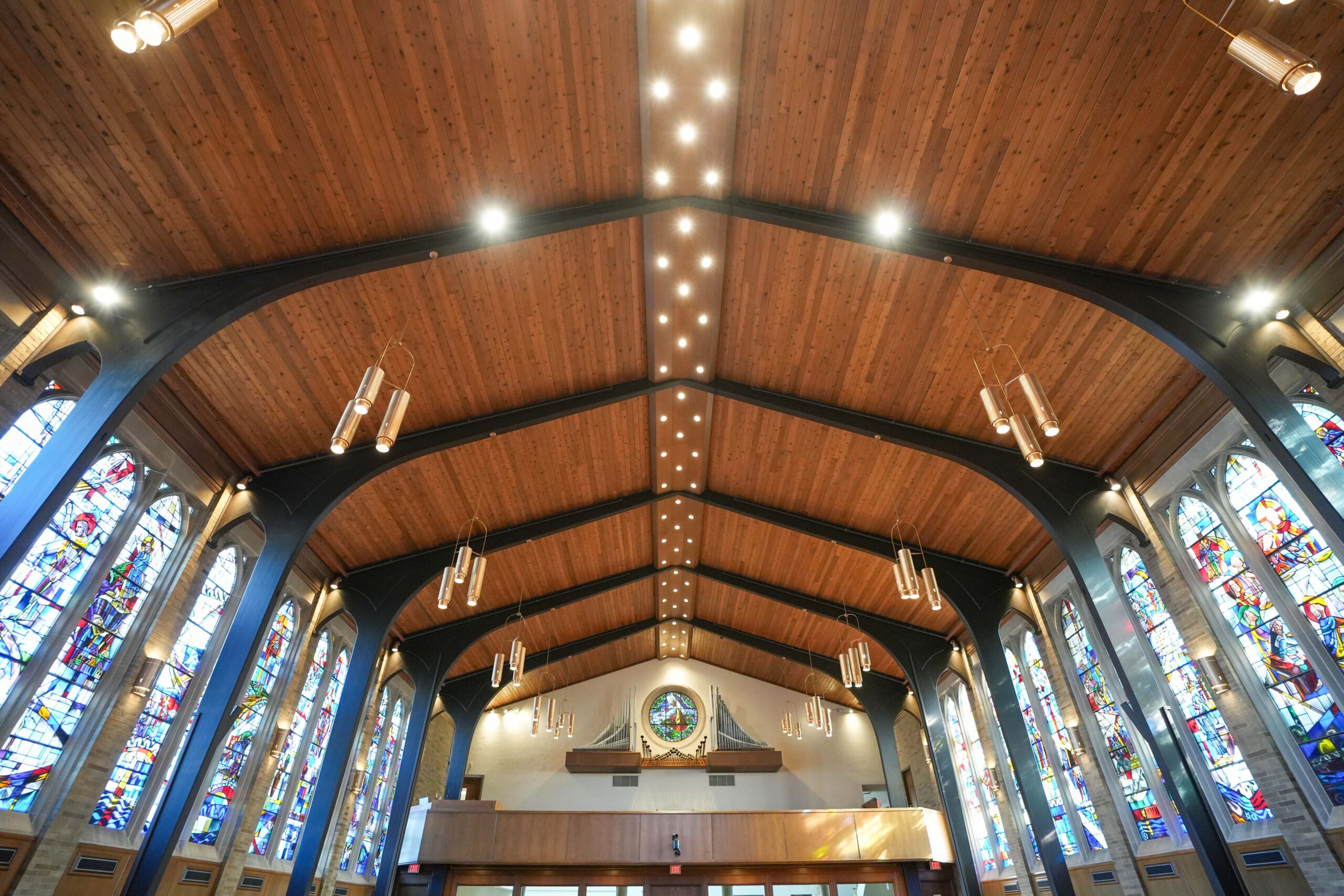 Ceiling view of LaGrave Avenue CRC sanctuary in Grand Rapids with wood beams, LED lighting, and hanging pendant fixtures installed by Buist.