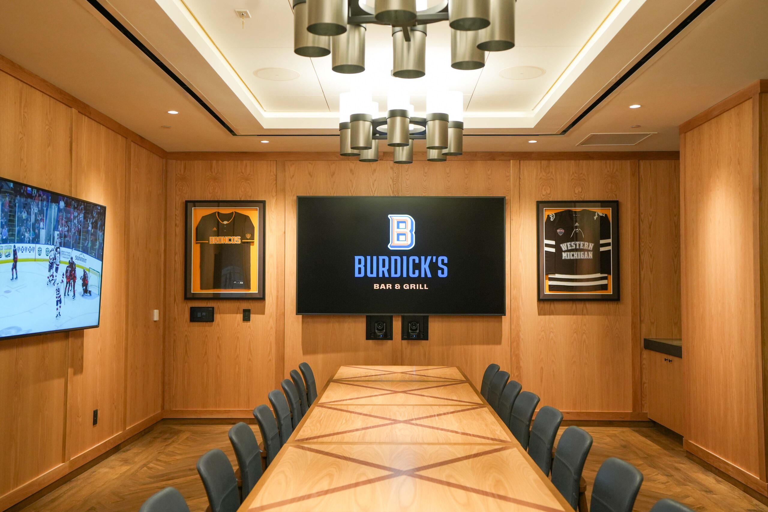 Conference-style private room at Burdick’s Bar & Grill equipped with integrated AV displays and wall-mounted screens.