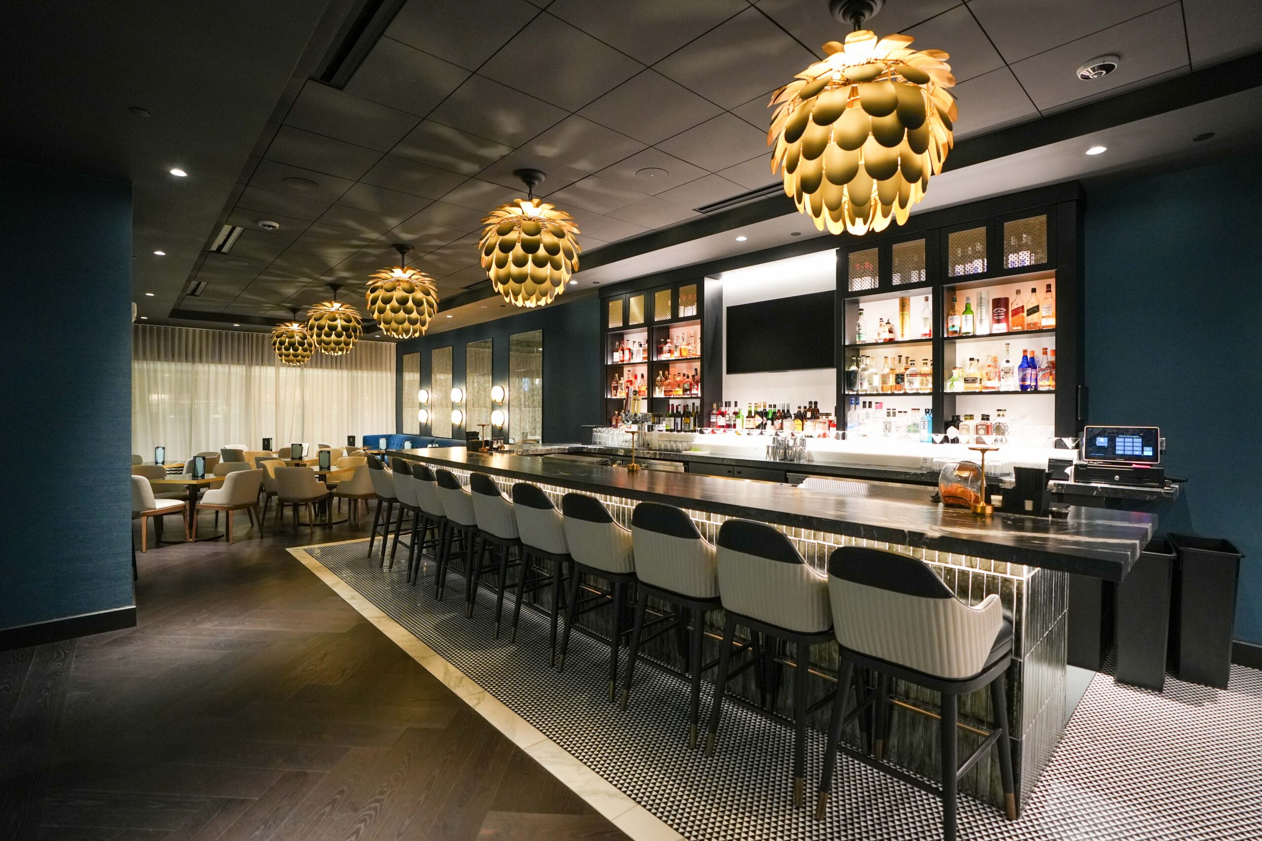 Full view of the Burdick’s Bar & Grill bar area with wraparound LED video walls and leather seating.