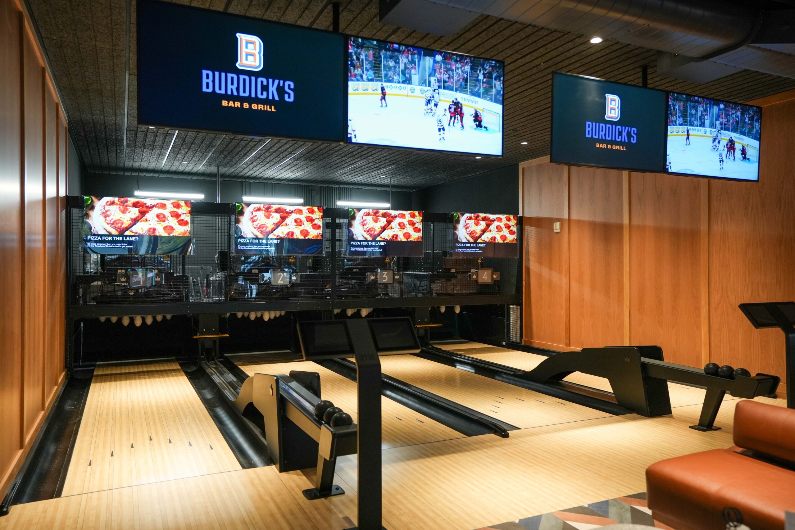 Duckpin bowling lanes at Burdick’s Bar & Grill with digital displays showing live sports and branded content.