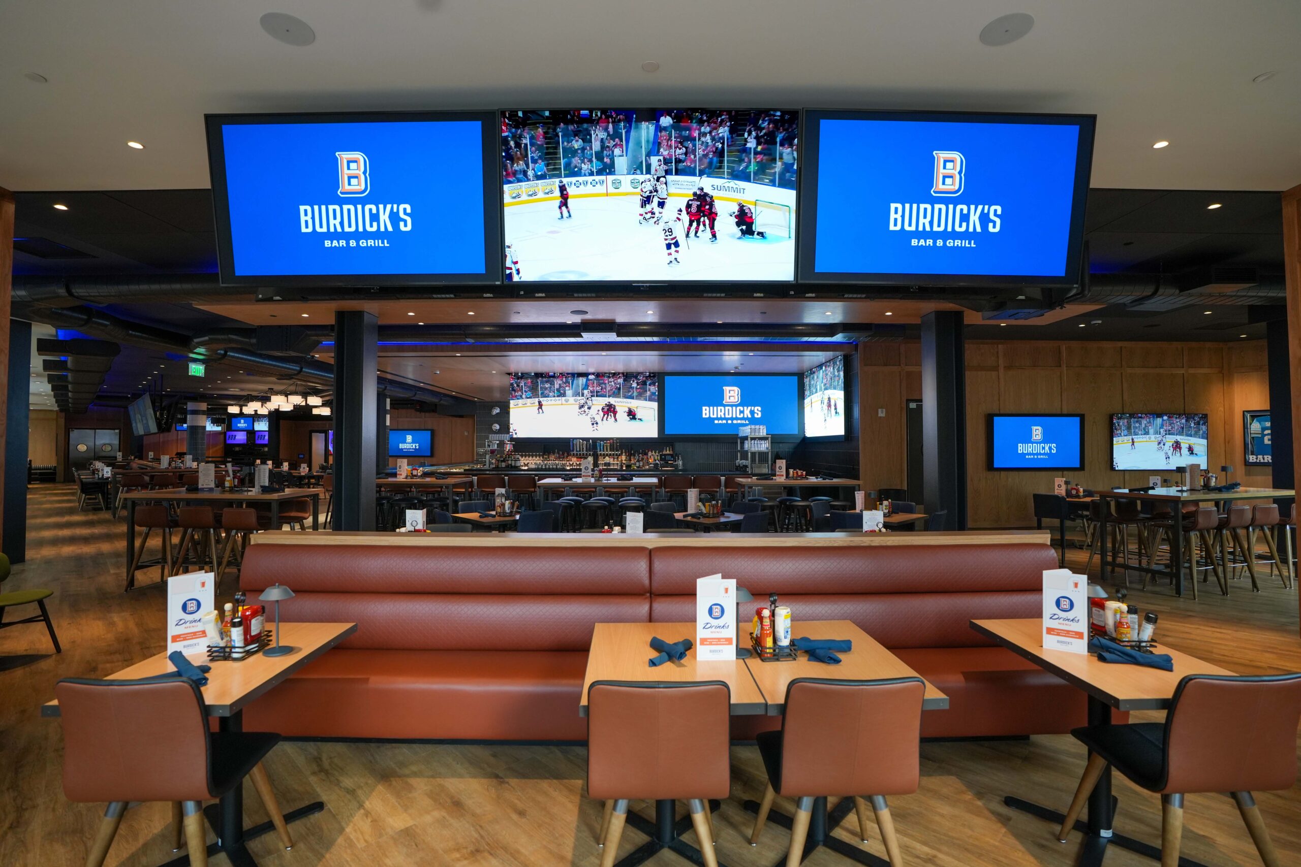 Burdick’s dining space with multiple wall-mounted displays and wood-accented interiors.