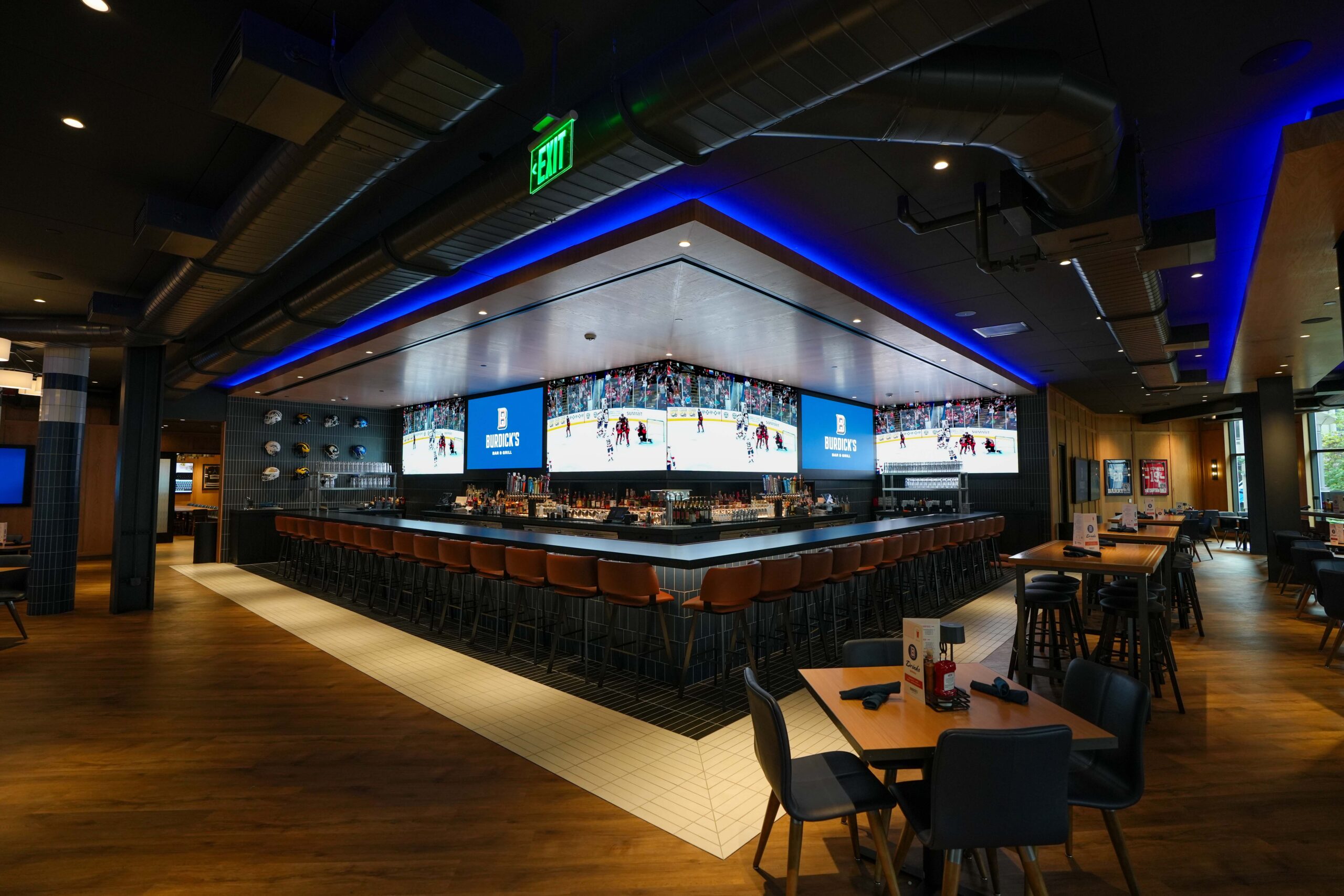 Panoramic view of Burdick’s Bar & Grill main bar surrounded by large LED video walls and accent lighting.