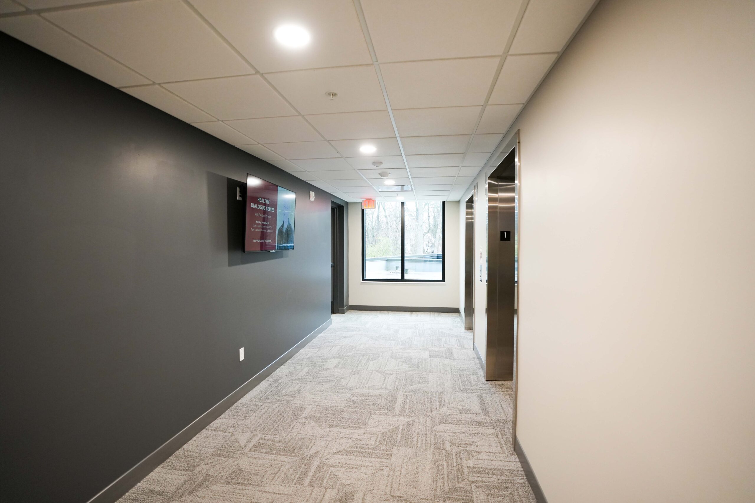 Interior entry hallway at Calvin Theological Seminary housing with LED lighting and digital display installed by Buist.