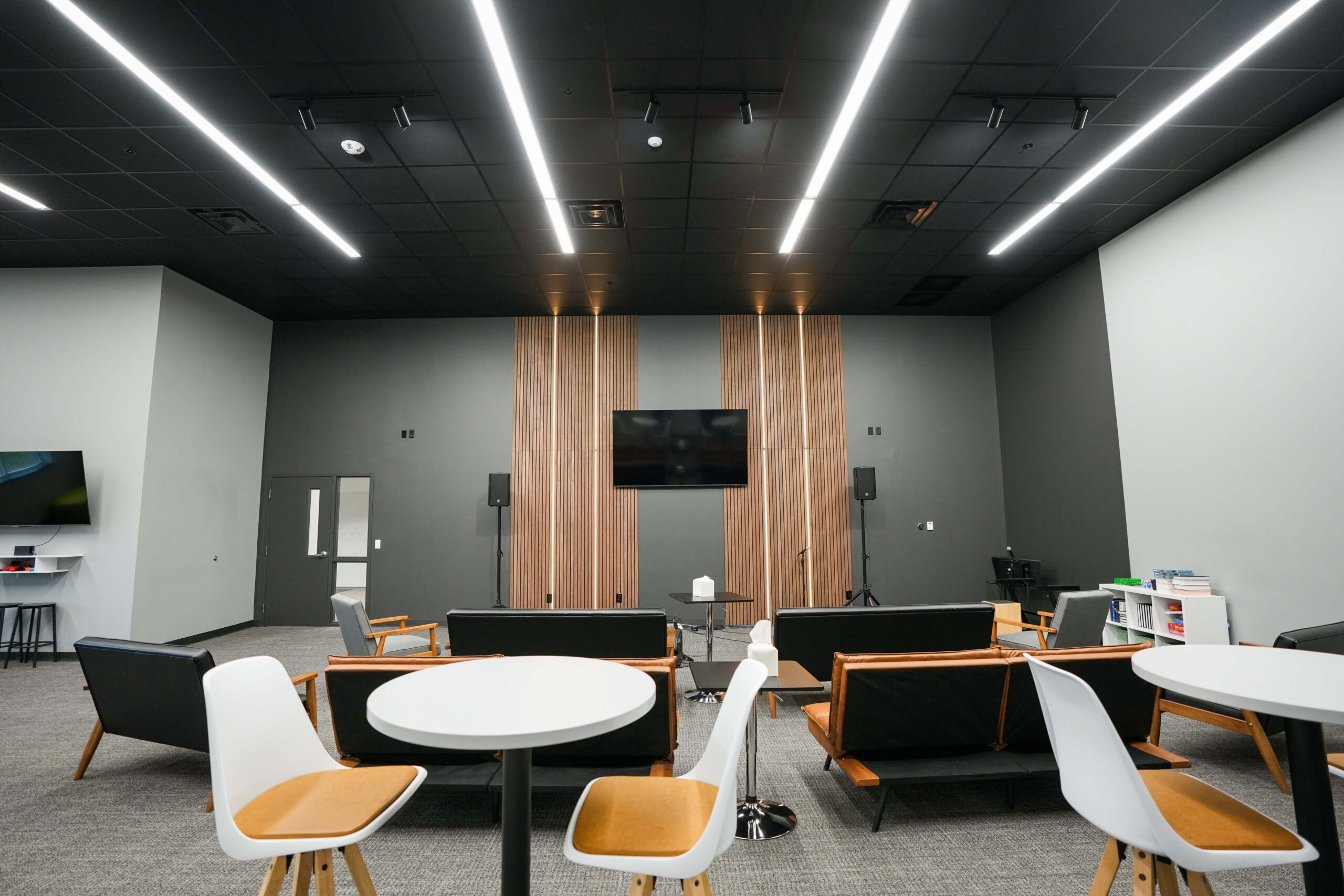 Youth lounge with seating, TV, and updated lighting