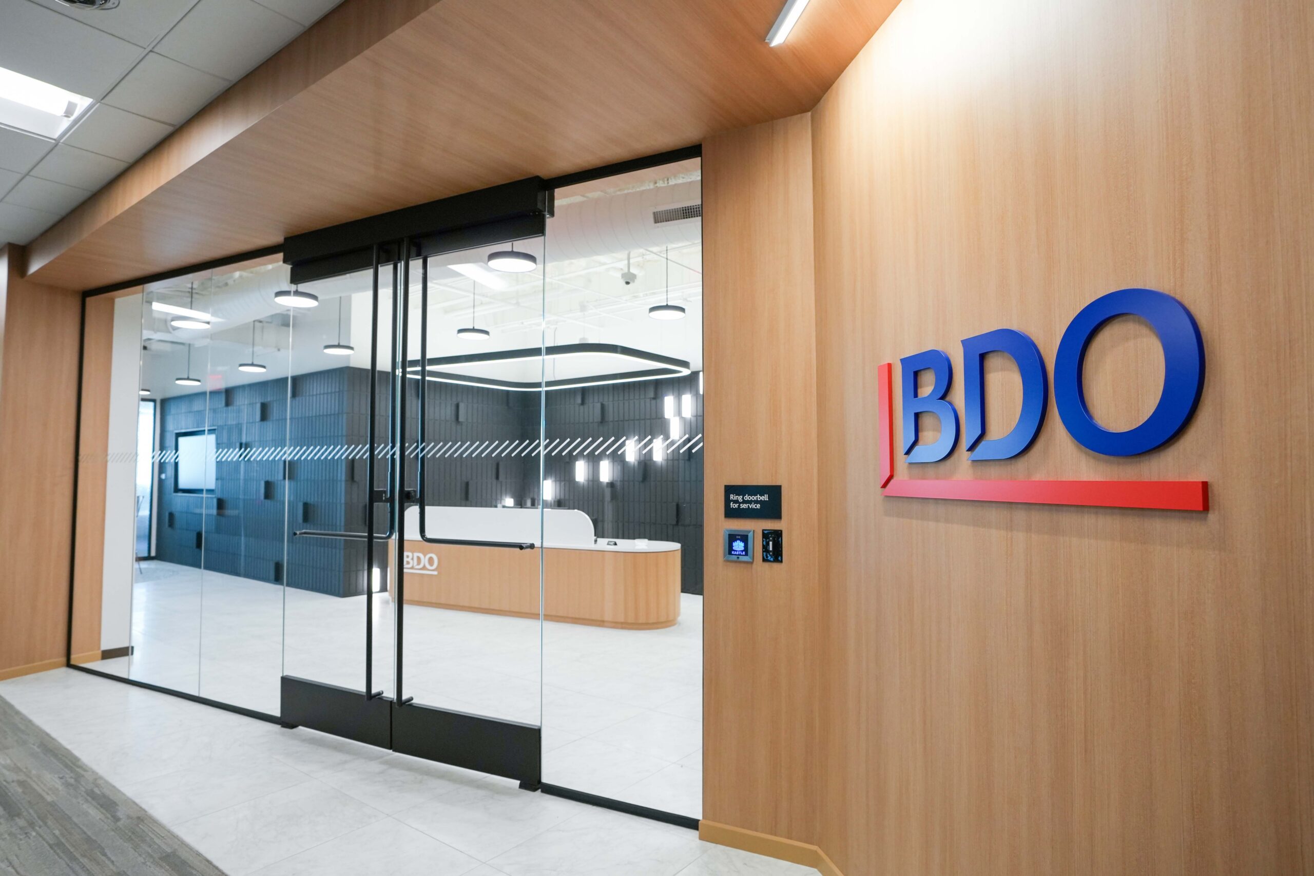 Entrance to BDO’s Grand Rapids office with glass doors, BDO signage, and illuminated reception area.