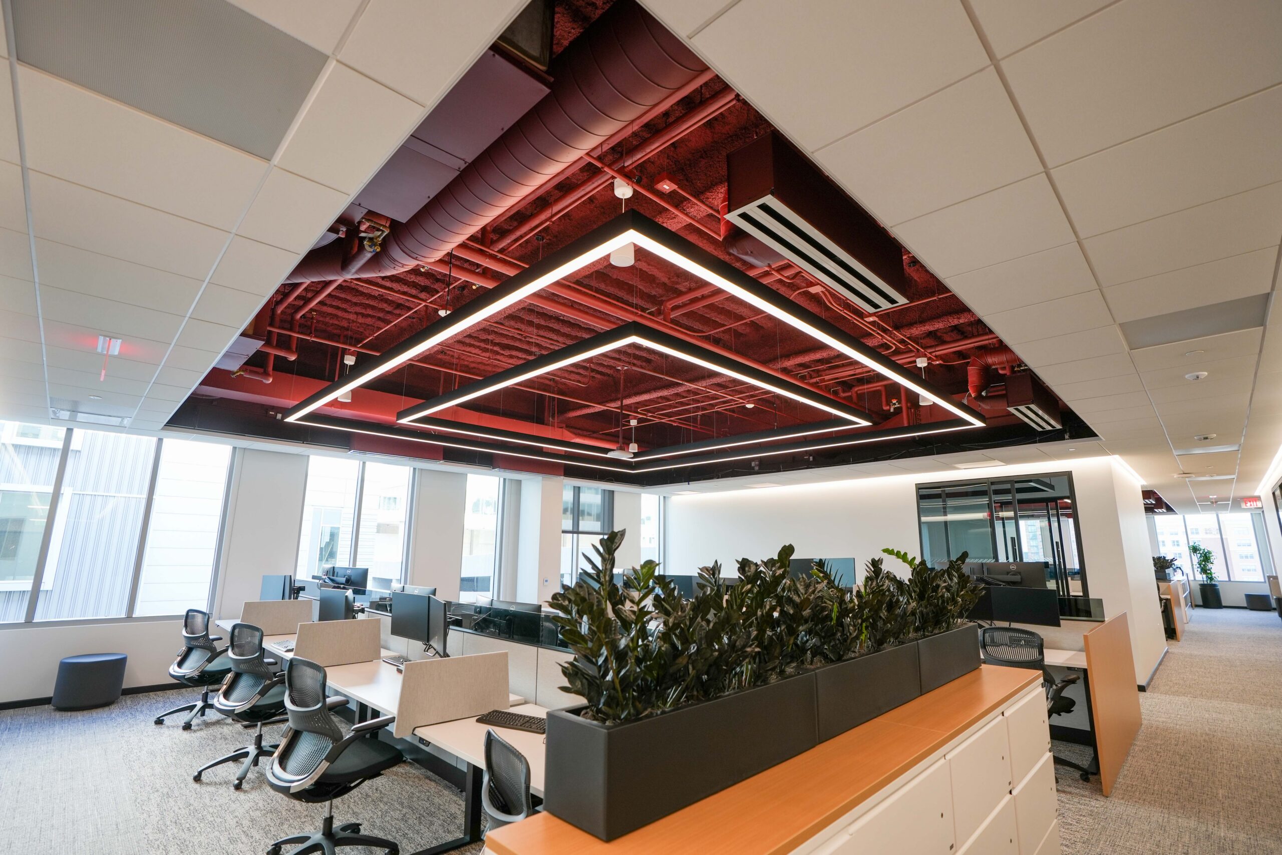Open workspace at BDO’s Grand Rapids office featuring geometric LED lighting and exposed ceiling systems.