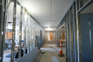 Interior construction progress at Alpha Grand Rapids with metal wall framing and electrical rough-in.