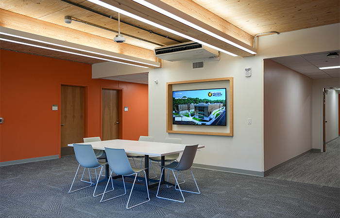 Western Michigan University Valley Oaks collaboration room featuring a wall-mounted commercial display and group seating.