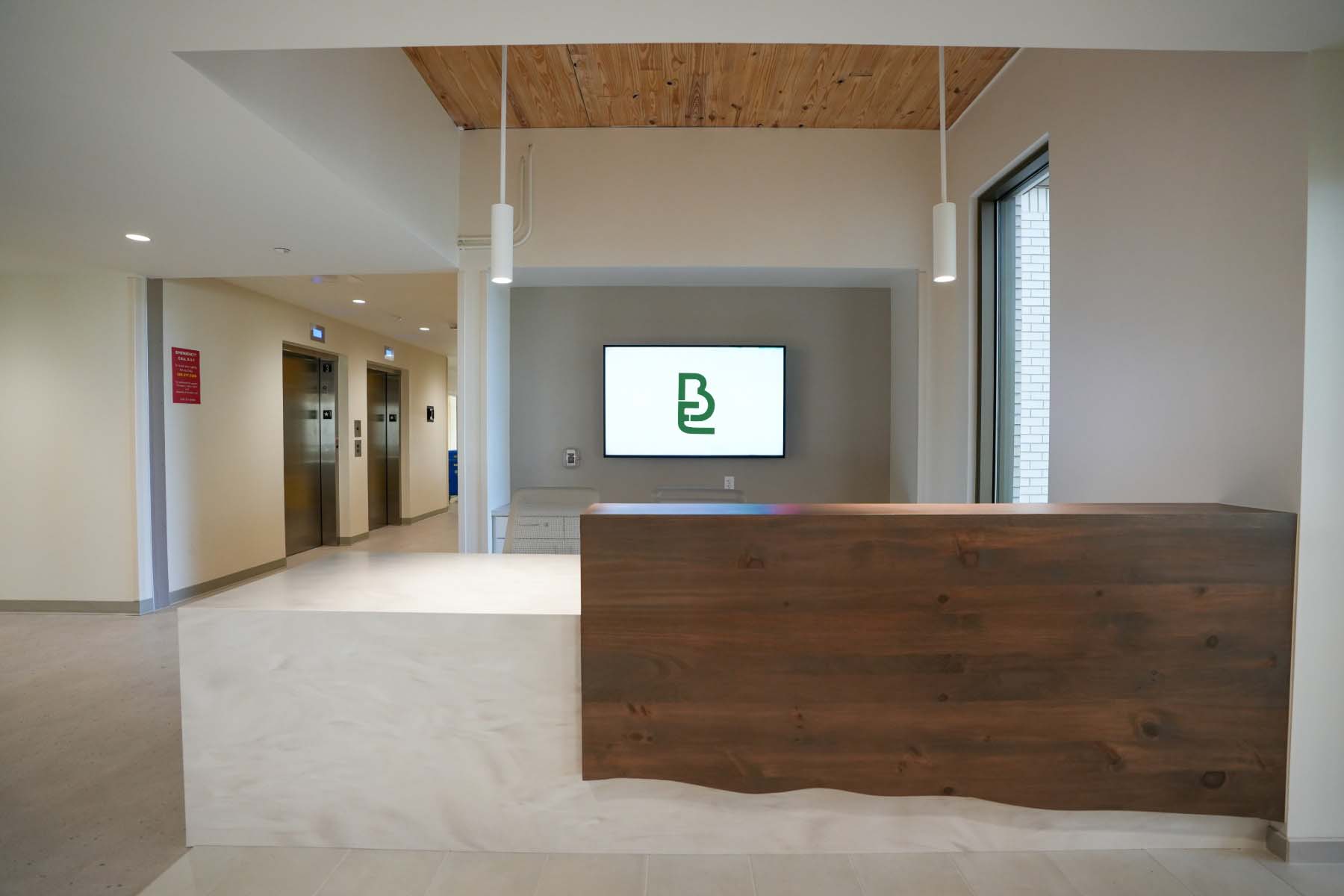 WMU Valley Oaks residence hall lobby featuring a wall-mounted digital signage display near the elevators.
