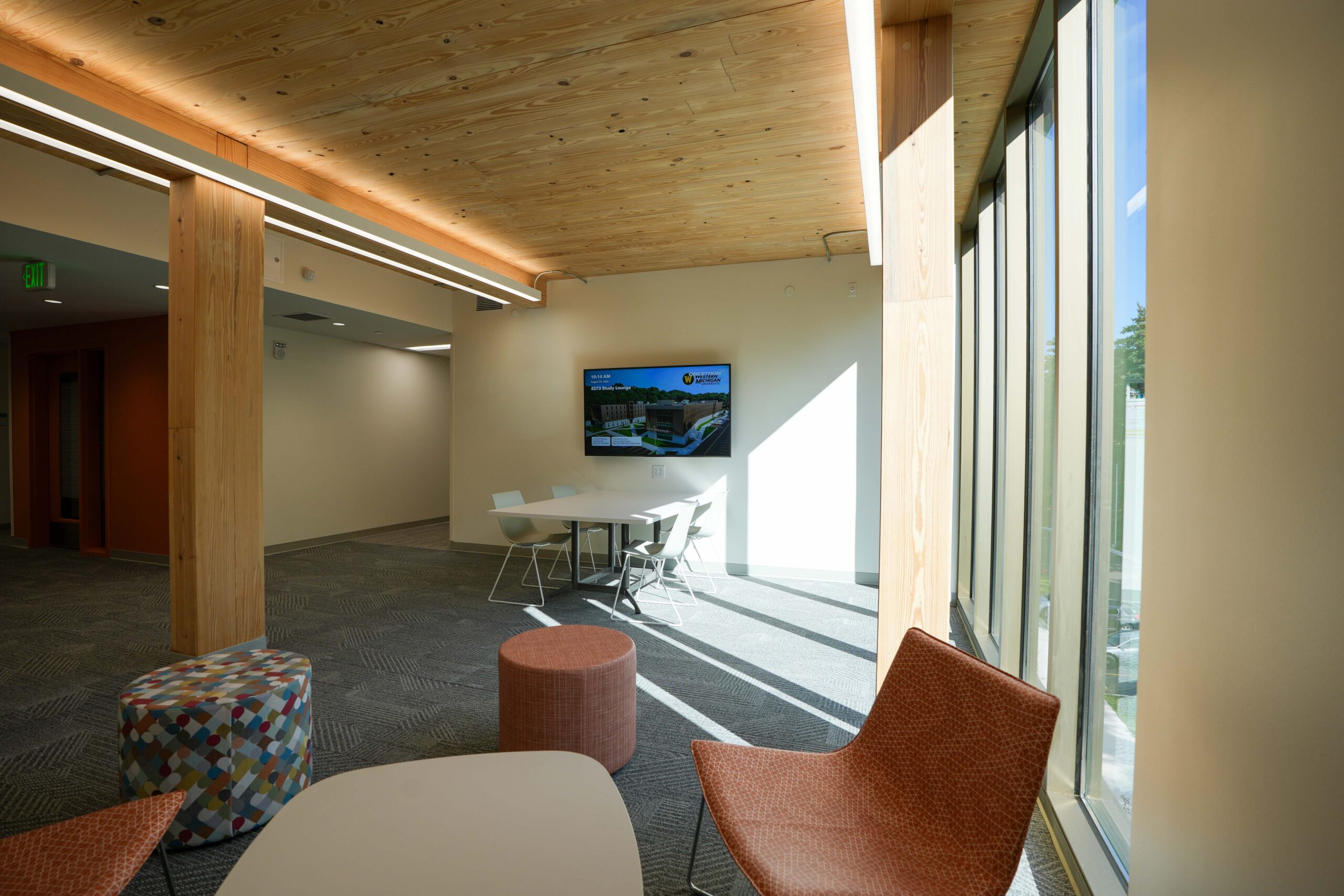 Western Michigan University Valley Oaks study lounge featuring a commercial display, group seating, and floor-to-ceiling windows.